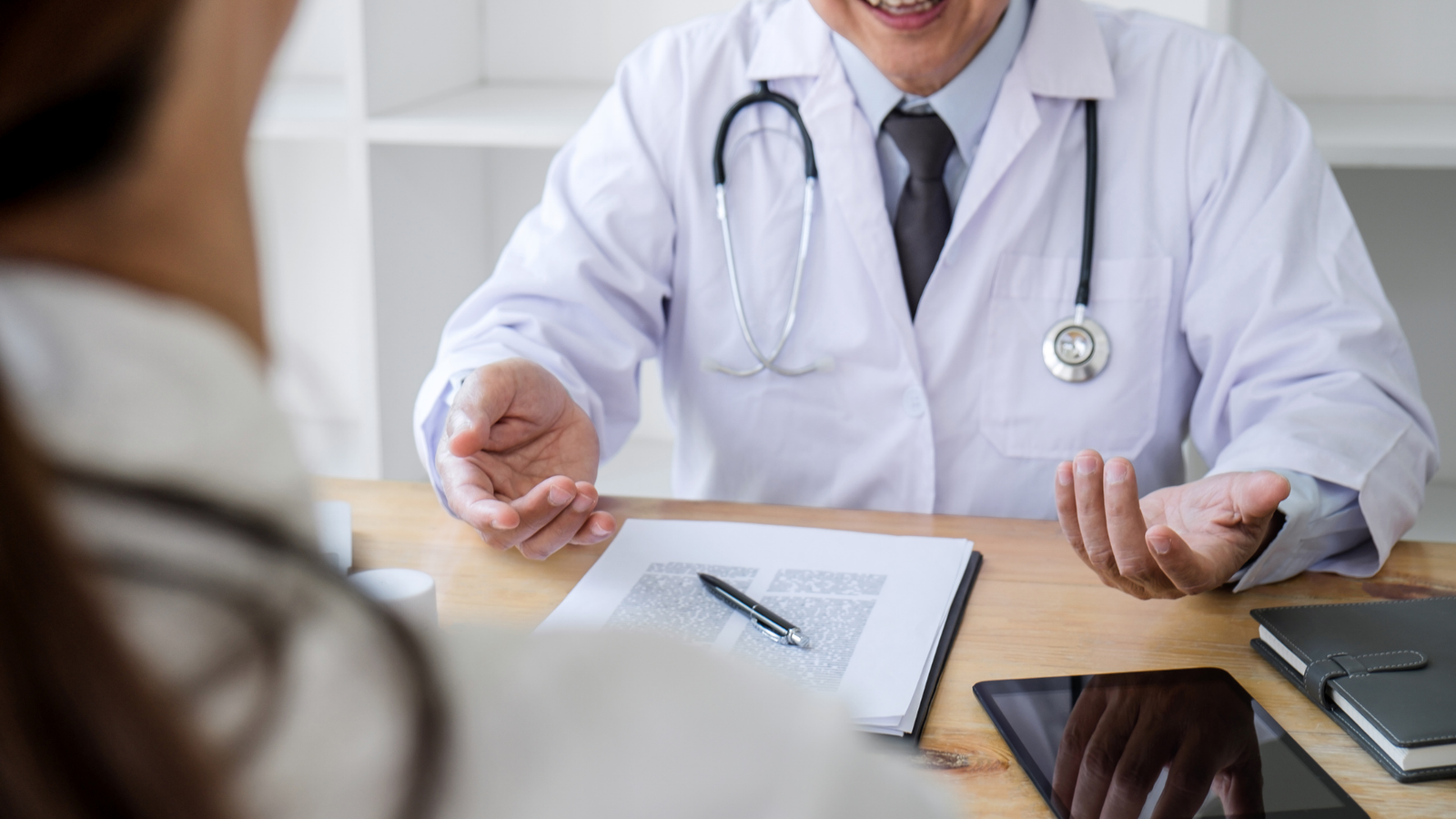 View of looking over a patient's shoulder sitting in front of a doctor.